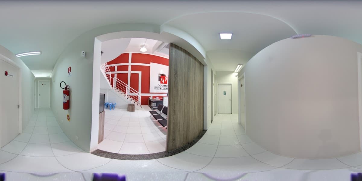 Visão do interior da clínica com recepção e corredores bem iluminados.